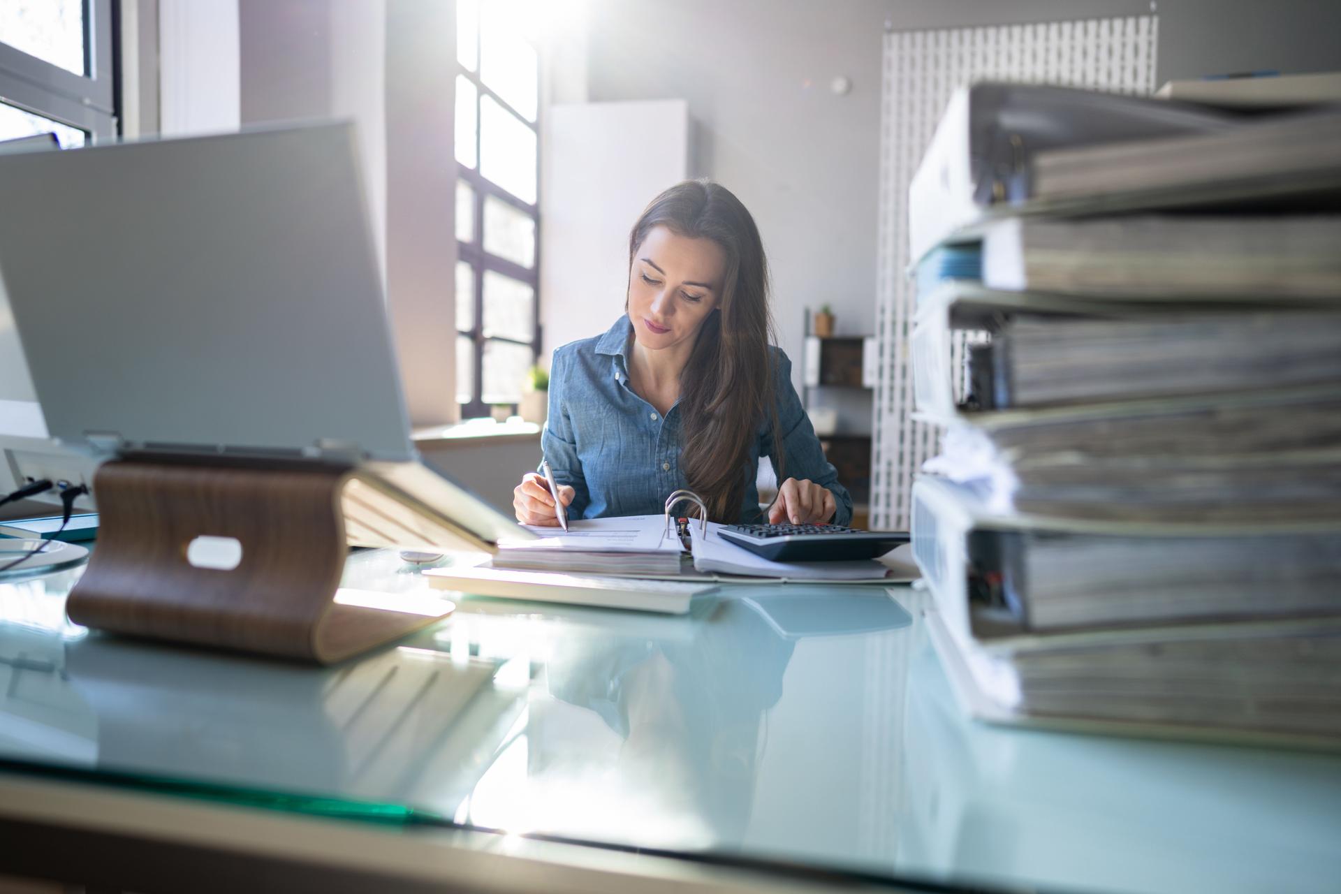 Young Businesswoman Working At Office With Stack Of Folders
